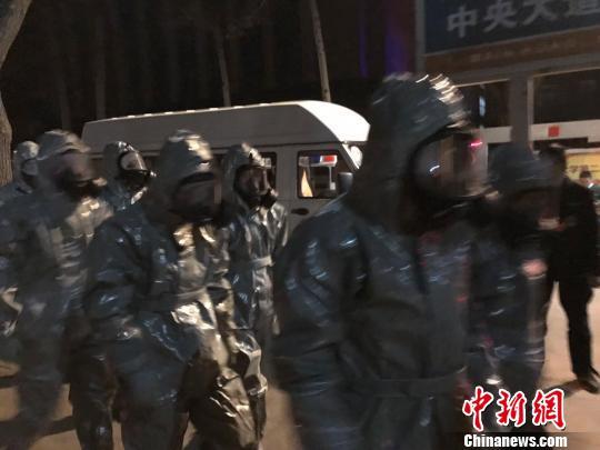 十几名身着防护服的人员头戴面具进入事发地。　胡健 摄